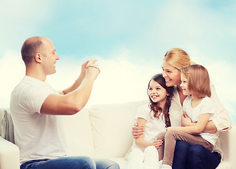 Image showing happy family with camera at home