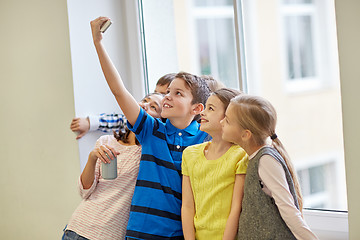 Image showing group of school kids with smartphone and soda cans