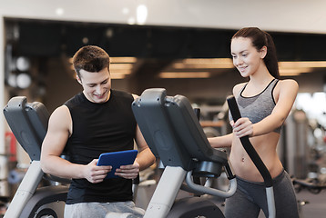 Image showing woman with trainer exercising on stepper in gym