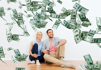 Image showing happy couple at home over dollar money falling