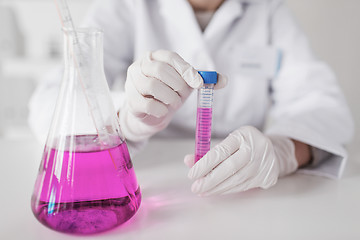 Image showing close up of scientist with tube in laboratory