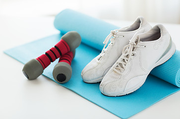 Image showing close up of sneakers, dumbbells and sports mat