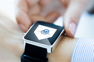Image showing close up of hands with email icon on smartwatch