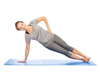 Image showing woman making yoga in side plank pose on mat