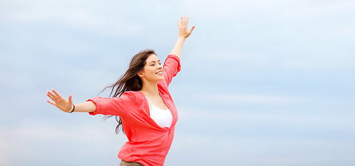 Image showing girl with hands up on the beach