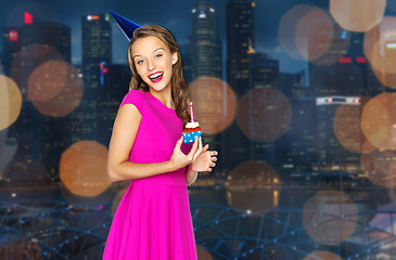 Image showing happy woman with birthday cupcake over night city 