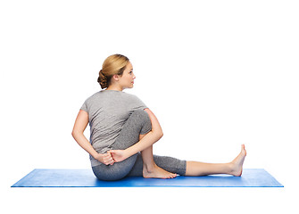 Image showing woman making yoga in twist pose on mat