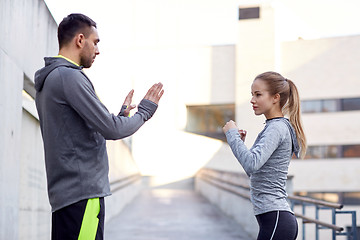 Image showing woman with coach working out strike outdoors