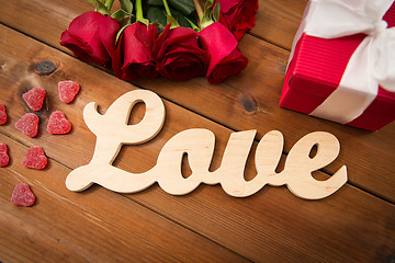 Image showing close up of gift box, red roses and greeting card