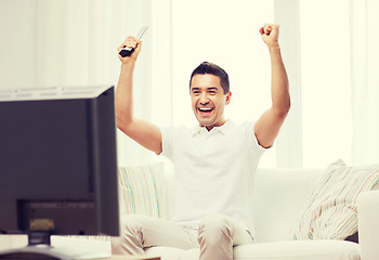 Image showing smiling man watching sports at home