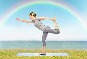 Image showing woman making yoga in lord of the dance pose on mat