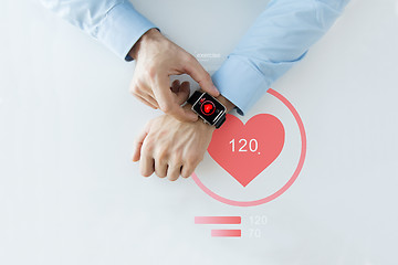 Image showing close up of hands with heart icon on smart watch