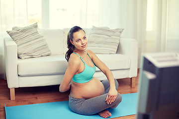 Image showing happy pregnant woman exercising at home