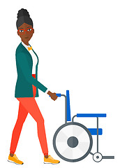 Image showing Woman pushing wheelchair.