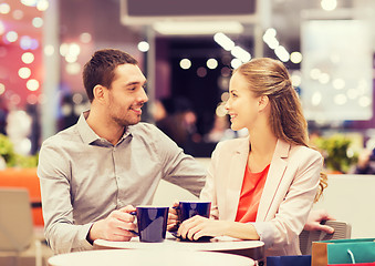 Image showing happy couple with shopping bags drinking coffee