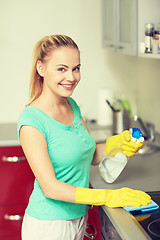 Image showing happy woman cleaning cooker at home kitchen