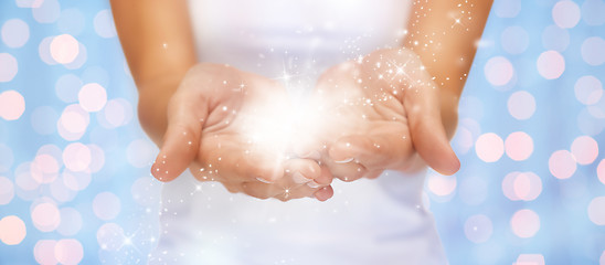 Image showing magic twinkles or fairy dust on female hands