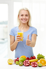 Image showing woman drinking fruit juice and showing thumbs up