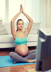 Image showing happy pregnant woman meditating at home