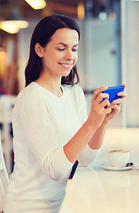 Image showing smiling woman with smartphone and coffee at cafe