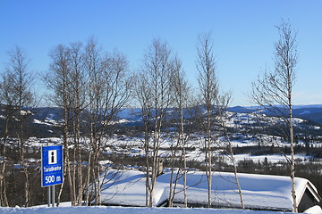 Image showing Tourist office sign and cabins in winter landscape