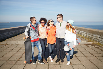 Image showing happy teenage friends with longboards on street