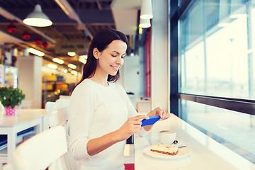 Image showing smiling woman with smartphone and coffee at cafe