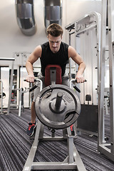 Image showing young man exercising on t-bar row machine in gym