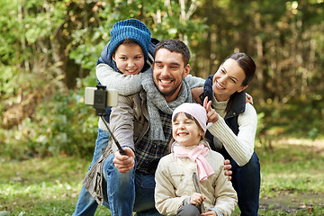 Image showing happy family with smartphone selfie stick in woods