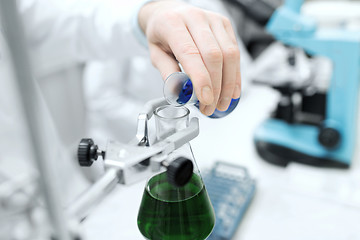 Image showing close up of scientist filling test tubes in lab