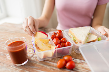 Image showing close up of woman with food in plastic container