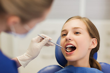 Image showing female dentist checking patient girl teeth