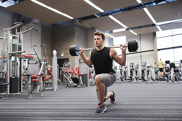 Image showing young man flexing muscles with barbell in gym