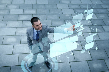 Image showing smiling businessman with virtual screens outdoors