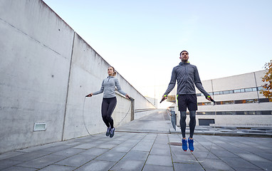 Image showing man and woman exercising with jump-rope outdoors