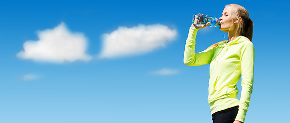 Image showing woman drinking water after doing sports outdoors