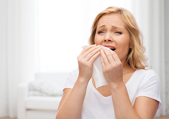 Image showing unhappy woman with paper napkin sneezing