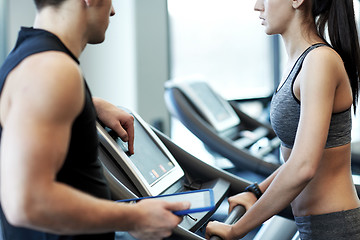 Image showing close up of woman with trainer on treadmill in gym
