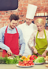 Image showing happy couple and male chef cook cooking in kitchen