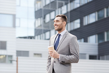 Image showing young serious businessman with paper cup outdoors