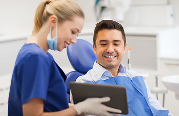 Image showing female dentist with tablet pc and male patient