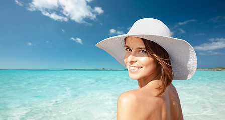 Image showing happy young woman in sunhat over summer beach