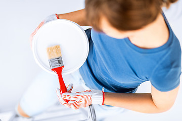 Image showing woman with paintbrush and paint pot