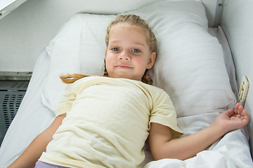 Image showing Four-year girl lies on a bed in a train