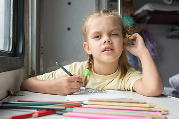 Image showing A six-year girl in the picture looked drawing pencils in a second-class train carriag
