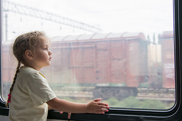 Image showing Girl thoughtfully looking into the distance from a train window