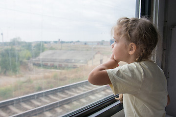 Image showing The girl sadly looking out the window of a train car