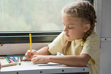 Image showing Six year old girl draws pencils in second-class train carriage