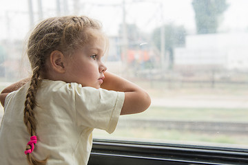 Image showing Girl with anxiety and sadness looks out the window of the train car