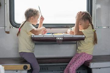 Image showing Two girls painted for the side table in the second-class train carriage